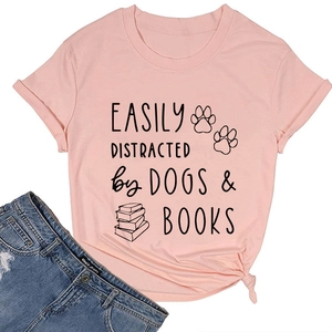 Detail view of pink cotton T-shirt featuring dogs and books graphic and black text