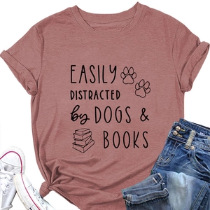 Flat lay of pink cotton T-shirt featuring 'EASILY DISTRACTED by DOGS & BOOKS' print