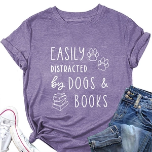 Flat lay of purple cotton T-shirt featuring dogs and books graphic with denim jeans