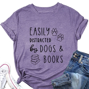 Flat lay of purple casual cotton T-shirt with dog and book print and lifestyle accessories