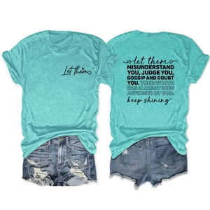 Détail macro du t-shirt bleu ciel avec citations noires et short en jean assorti