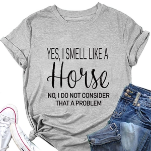 Detailopname van grijs T-shirt met paardentekst print en spijkerbroek op witte basis