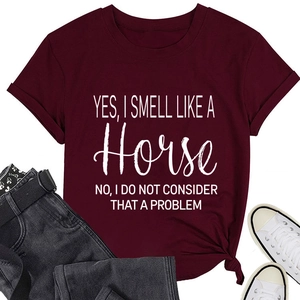 Detail van bordeauxrood T-shirt met witte letterprint, opgerolde mouwen en geknoopte zoom