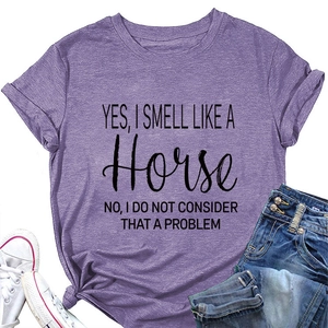 Close-up van een paars katoenen t-shirt met de tekst Yes I Smell Like A Horse