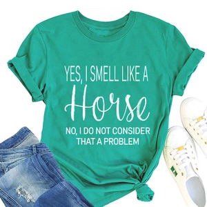 Gedetailleerde flat-lay van meer-groen T-shirt met grappige witte tekst over paarden