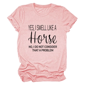 Macro detail van de 'Yes I smell like a horse' slogan op een roze gemêleerd katoenen t-shirt