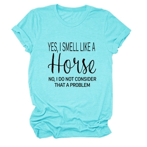Detail van een lichtblauw T-shirt met ronde hals en zwarte tekstprint over paarden