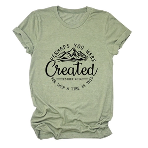 Détail du t-shirt vert gazon avec graphique de montagne noir et citation inspirante