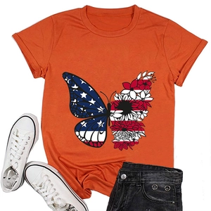 Detailed view of an orange butterfly T-shirt styled with black shorts and white sneakers
