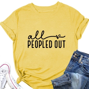 Close-up of mustard yellow t-shirt with all peopled out print, denim and sneakers