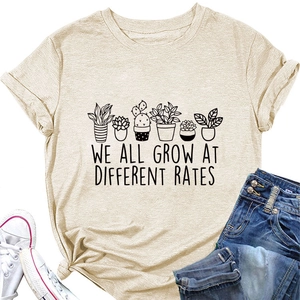 Detail of floral print and slogan WE ALL GROW AT DIFFERENT RATES on beige cotton T-shirt