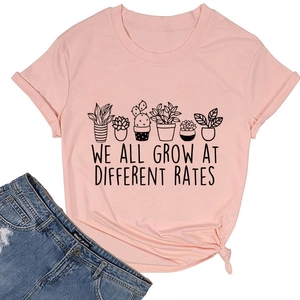 Flat lay of pink cotton T-shirt featuring potted plant prints and inspirational quote