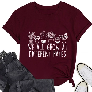 Flat lay of burgundy t-shirt featuring potted cactus graphic and motivational slogan