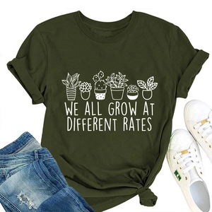 Flat lay of olive green cotton T-shirt with white plant print and motivational quote