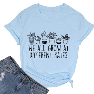 Detail of light blue cotton T-shirt featuring botanical print and knotted hem design