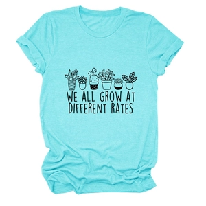 Detailed close-up of plant print and 'We all grow at different rates' text on teal T-shirt