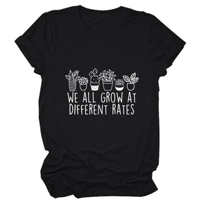 Detailed view of plant art print and We All Grow at Different Rates text on black tee