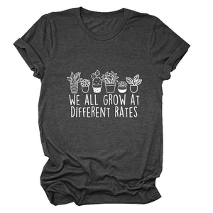 Detail of succulent plant graphic and We All Grow At Different Rates text on charcoal t-shirt