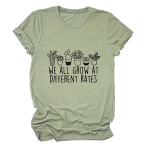Close-up of sage green T-shirt with plant illustration and motivational text