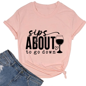 Détail à plat du t-shirt rose avec motif graphique sips about to go down et verre de vin