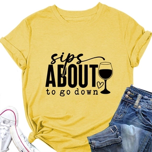 Détail du t-shirt jaune avec imprimé 'sips ABOUT to go down' et motif de verre à vin