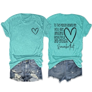 Détail de l'imprimé inspirant au dos sur t-shirt vert menthe avec short en jean usé