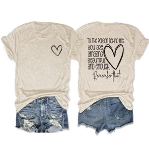 Détail d'un t-shirt oversize avoine avec motif de cœur et slogan au dos sur fond blanc