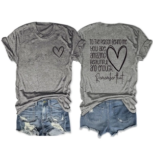 Détail d'un t-shirt gris en coton avec imprimé cœur et texte positif dans le dos