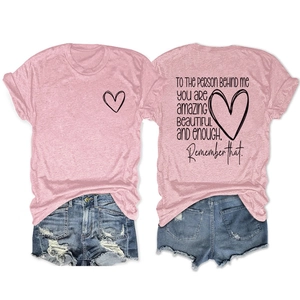 Détail d'un t-shirt rose à message motivant et d'un short en jean effet usé
