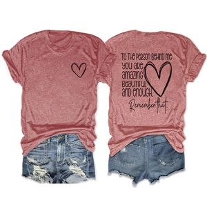 Détail du t-shirt rouge brique avec motif cœur et citation au dos avec short en jean