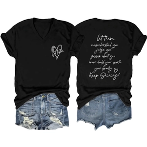 Detail van de artistieke tekstprint en distressed denim zoom op een zwart T-shirt met V-hals