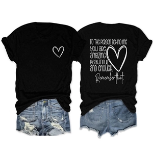 Détail du t-shirt noir en coton avec imprimé cœur et texte inspirant au dos du vêtement
