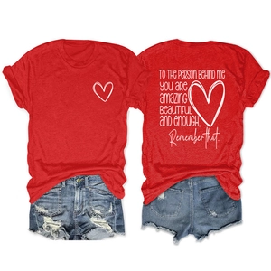 Détail du dos d'un t-shirt rouge avec citation inspirante blanche et motif cœur