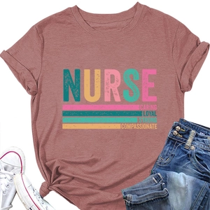 Flat lay of pink nurse t-shirt with rainbow print paired with denim shorts and shoes