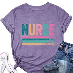 Flat lay of purple Nurse T-shirt with Caring Loyal Strong text, jeans and sneakers