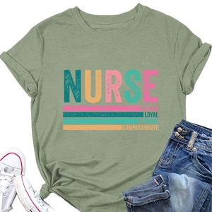 Detailed flat lay of sage green nurse t-shirt with artistic typography and denim shorts