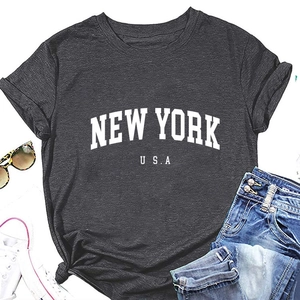 Flat lay of a charcoal New York USA printed t-shirt with denim shorts and accessories