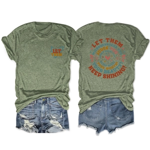 Flat lay of green t-shirt with Let Them slogan and distressed blue denim shorts