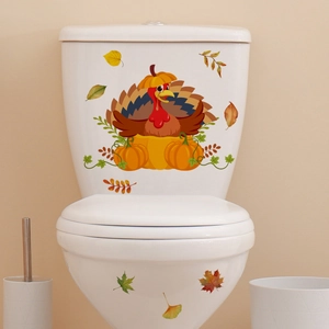 Cartoon turkey and pumpkin decals on a white toilet for Thanksgiving bathroom decoration