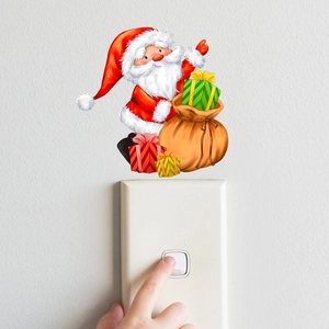 Adesivo natalizio fluorescente con Babbo Natale applicato sopra un interruttore