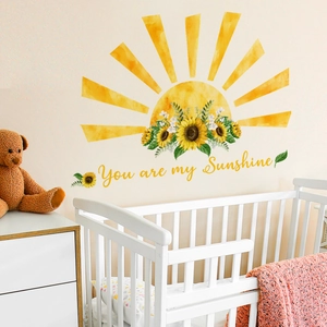 Detail of yellow sunflower wall decals with You are my Sunshine text in a warm nursery room
