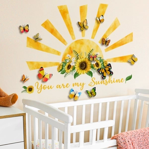Detail of You are my Sunshine sunflower wall decals and 3D butterflies over a white crib