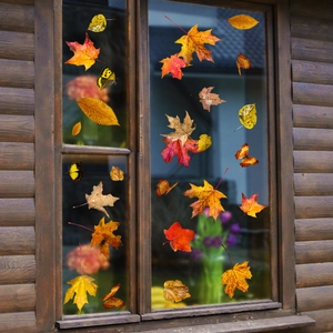 Vue détaillée d'autocollants de feuilles d'érable et de papillons sur une vitre