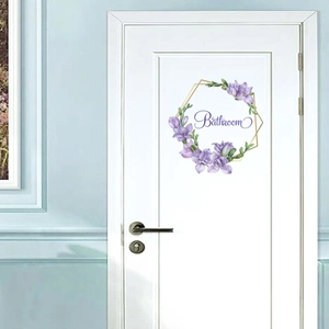 Purple floral wreath bathroom door sticker with Bathroom text on a white wooden door
