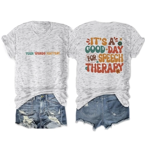 Flat lay of gray T-shirt with vintage colorful text and denim shorts on white background