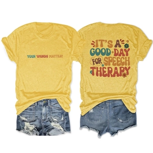 Flat lay of mustard yellow T-shirt with vintage floral speech therapy slogan