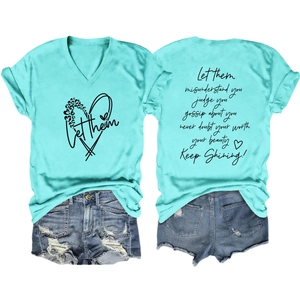Détail du t-shirt col V vert menthe avec impression Let Them au dos et texte inspirant