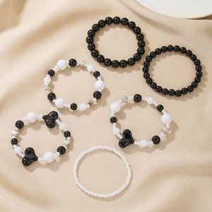Detailset aus sechs schwarz-weißen Perlenarmbändern mit Herz- und Sternanhängern