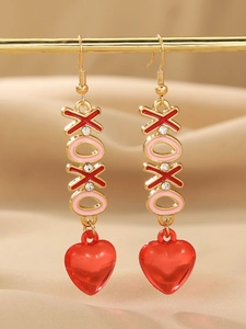 Detail of gold XOXO earrings with red enamel hearts and sparkling rhinestones