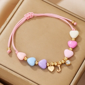 Close-up of pink adjustable braided bracelet with colorful heart beads and gold J pendant